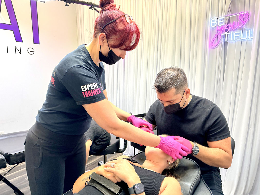 Students practicing partner brow mapping during microblading class in Texas