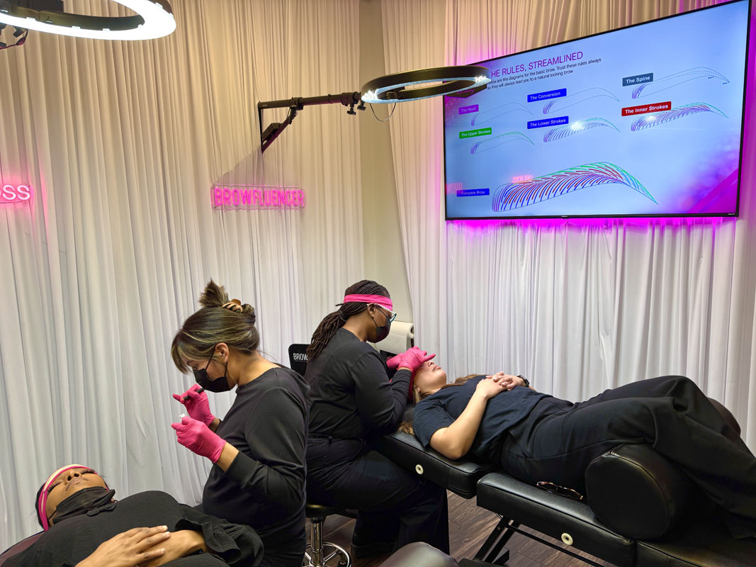 Student practicing brow strokes on silicone practice headbands in training