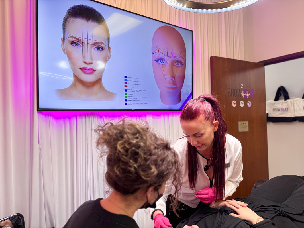 Mapping practice exercise on partner during Dallas brow certification Brows mapped with string on partner in classroom training