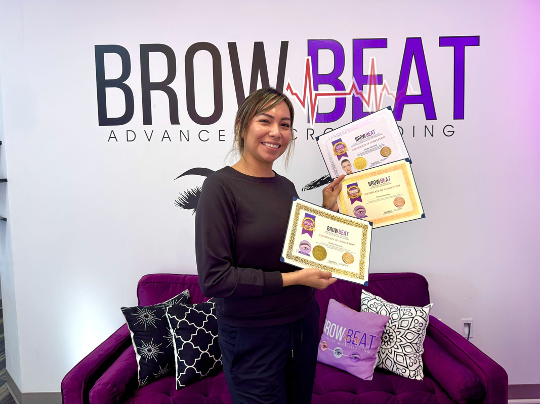 student at BrowBeat Academy holding certification