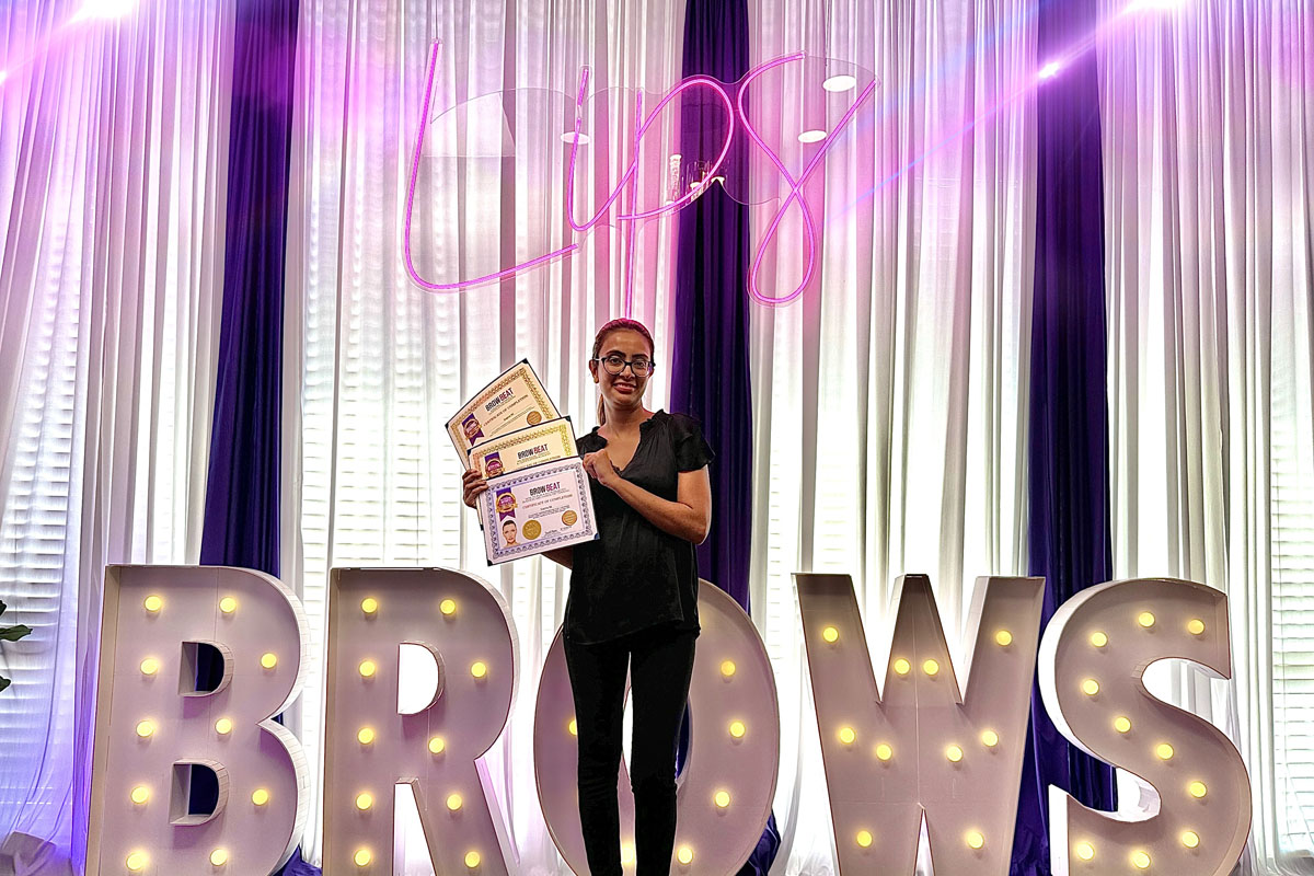 Graduate holding three certificates in Dallas brow training Certificates for microblading, ombré, and combo brows displayed after course
