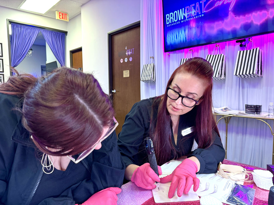 Student using PMU machine on silicone practice sheet in 3-in-1 course Machine shading on silicone skin during brow training