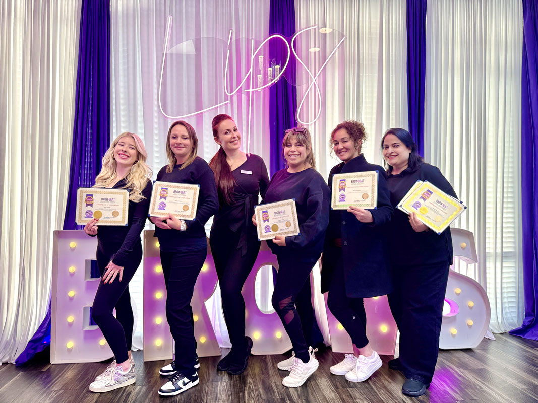Smiling students holding up brow certificates
